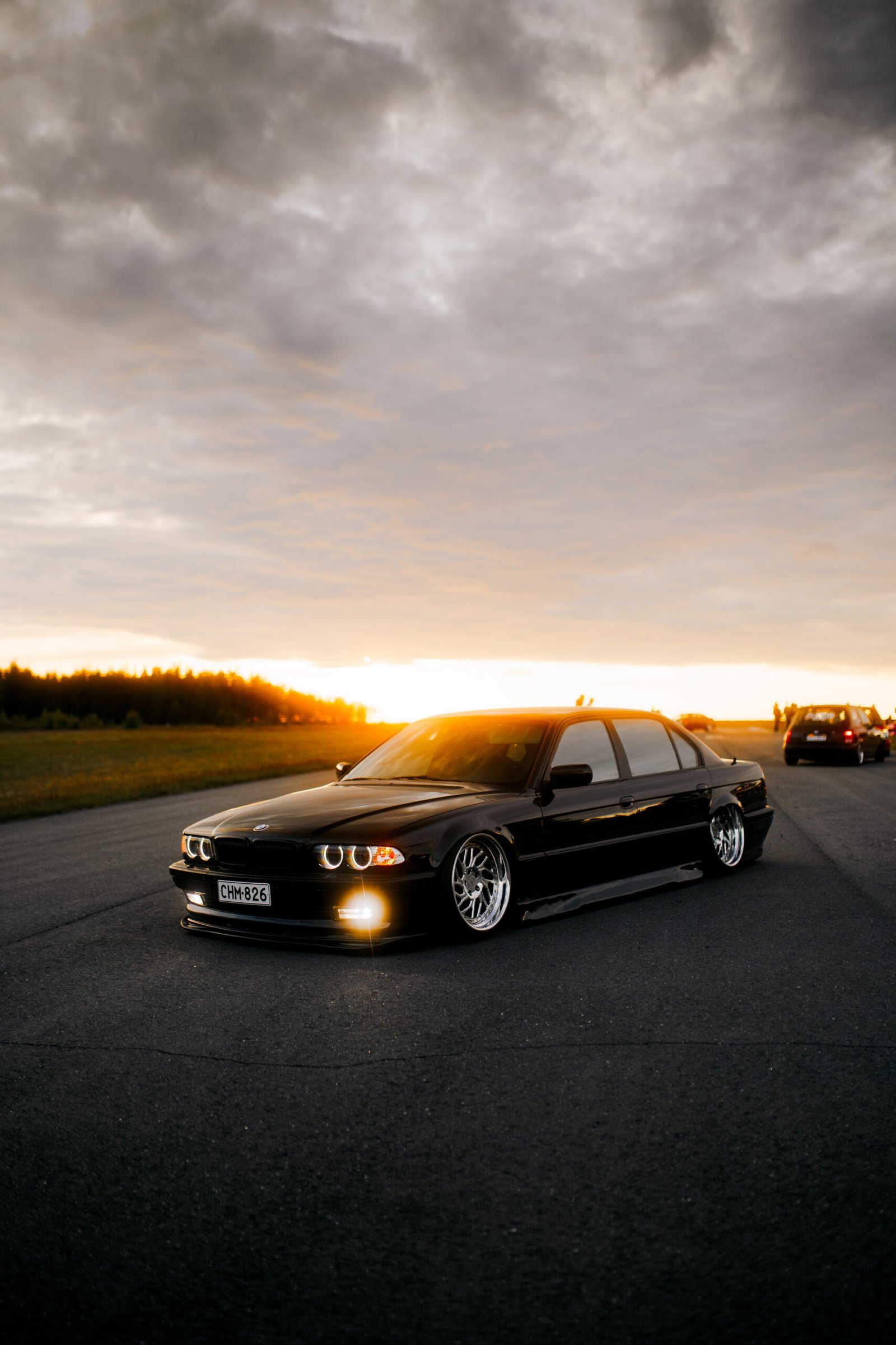 Black BMW 3 Series E36 with glowing angel-eye headlights at sunset – Wicked Street Customs